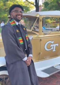 A man in a suit and tie standing next to a car.