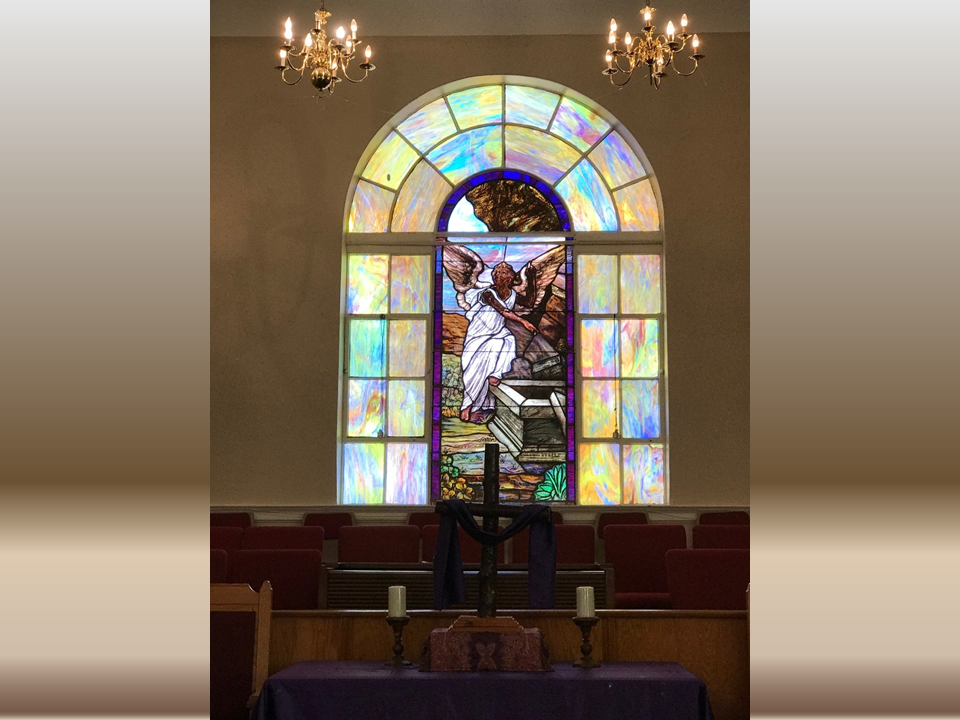 A stained glass window in the center of a church.