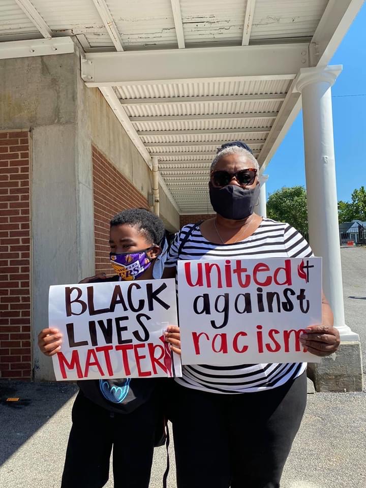 Two women holding signs that say " black lives matter ".