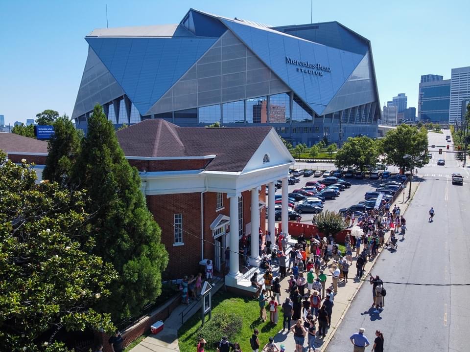 A large crowd of people are gathered outside the stadium.