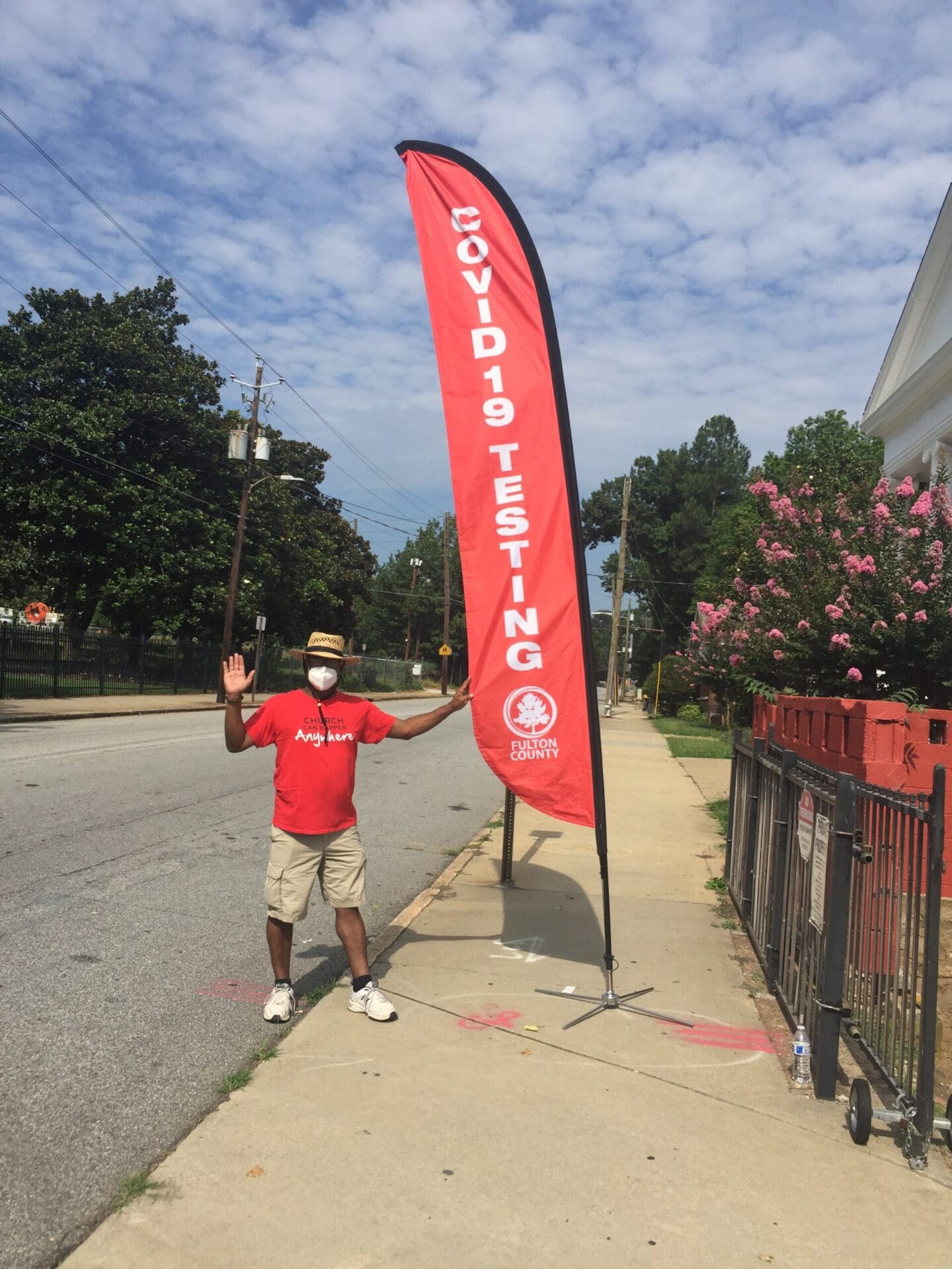 A man standing next to a red banner.