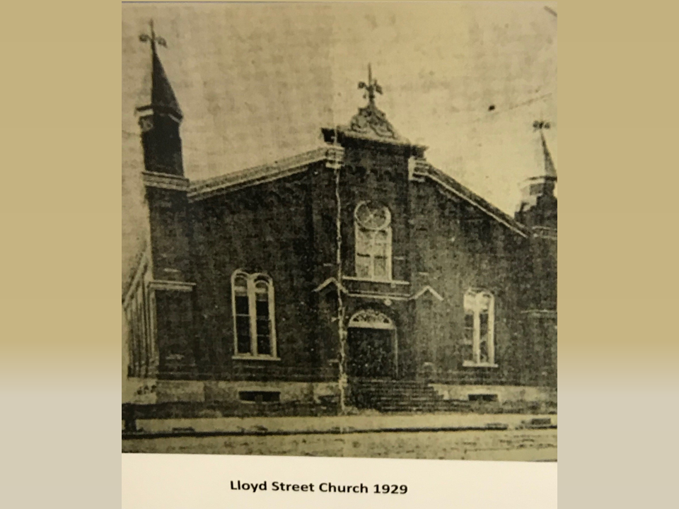 A black and white photo of the front of an old church.