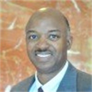 Harold Jordan final pic A man in a suit and tie smiling for the camera.