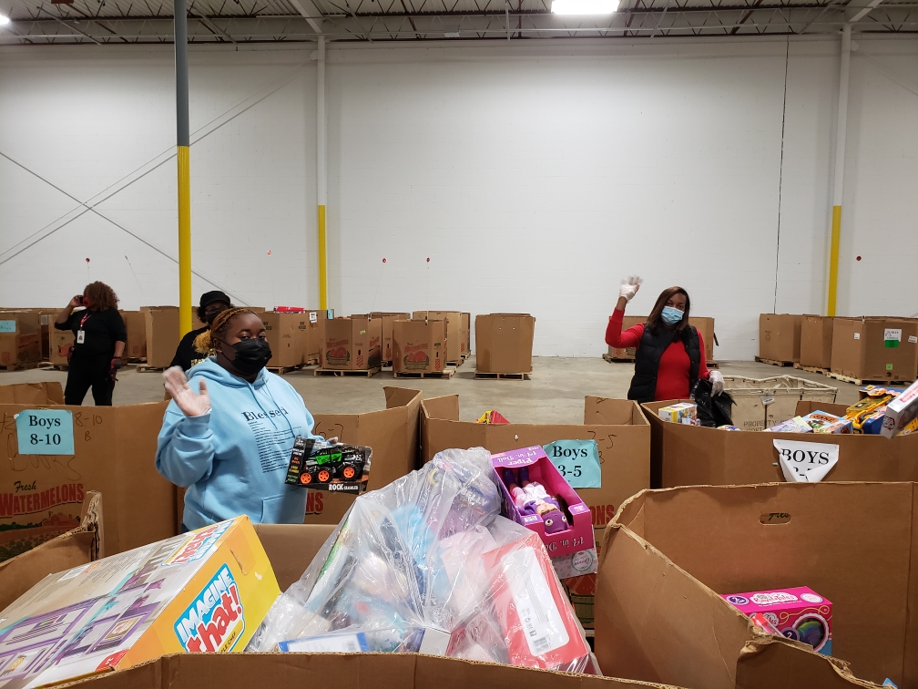 A group of people standing around boxes in a warehouse.