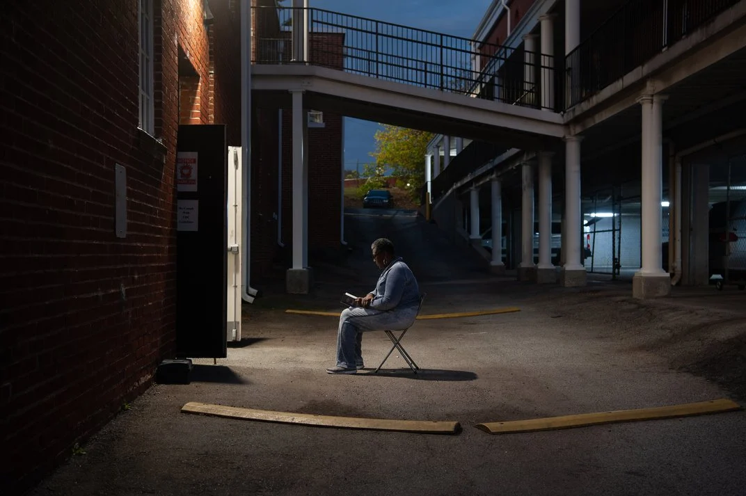 A person sitting in a chair on the street