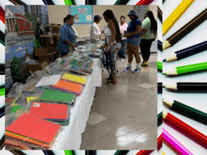 A group of people standing around a table with many books.