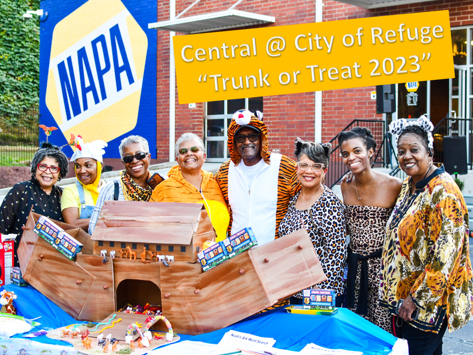 A group of people standing around a table with a boat.