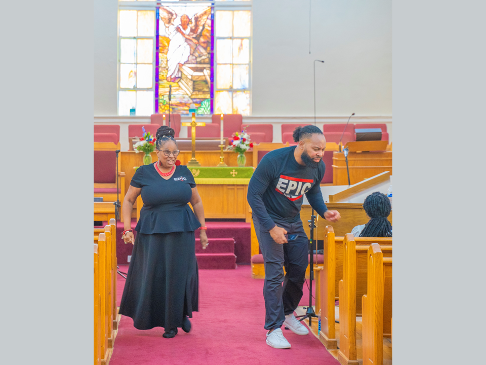 A man and woman walking down the aisle of a church.