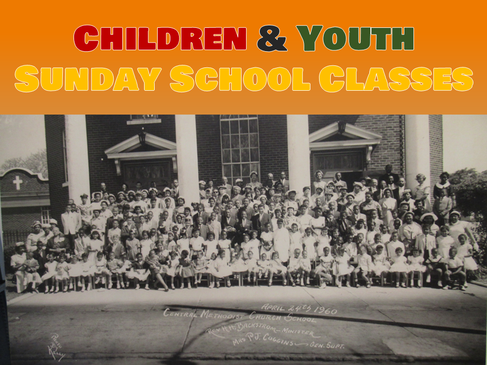 A group of children and youth in front of a building.