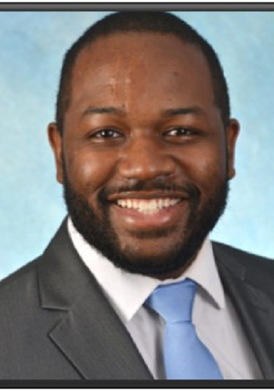 R Rowe Graduate 2022 v2 A man in a suit and tie smiling for the camera.