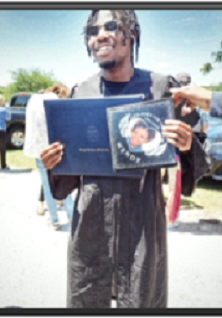 T Murphy 2022 v3 A man holding up a graduation cap and book.