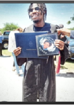 A man holding up a graduation cap and book.